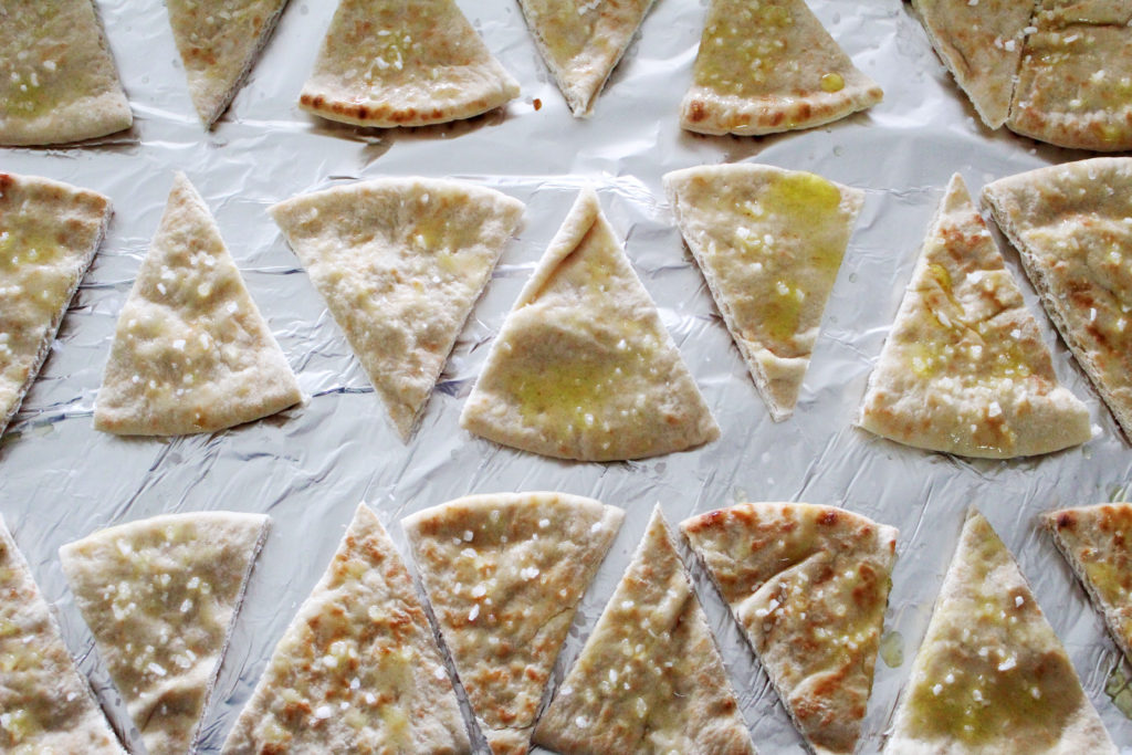 brushing oil and salt on pita bread