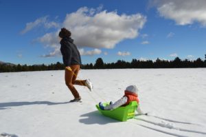 toddler sledding with mom