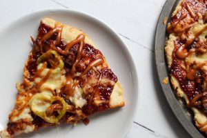 slice of pork pizza and pan of bbq pizza 1