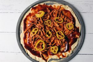 pizza crust with bbq sauce pulled pork and peppers-min