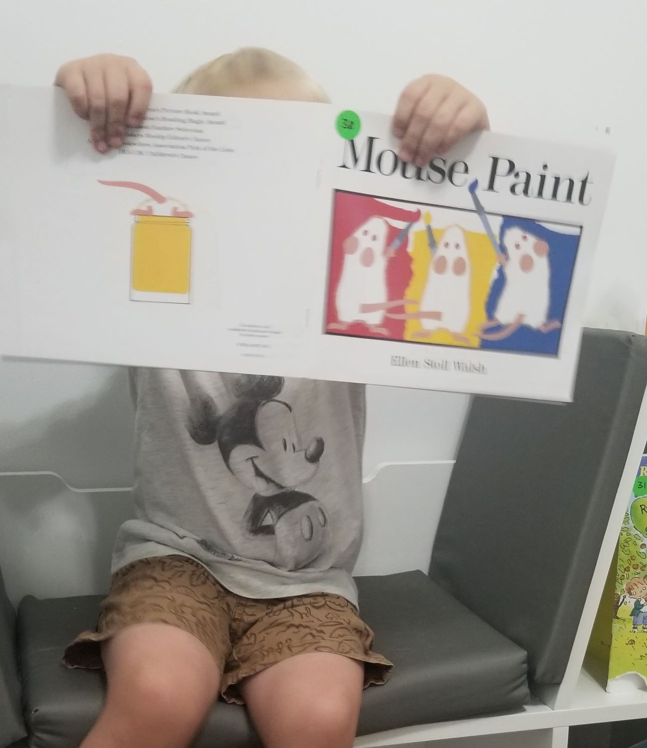 boy holding mouse paint book for color mixing activity 1