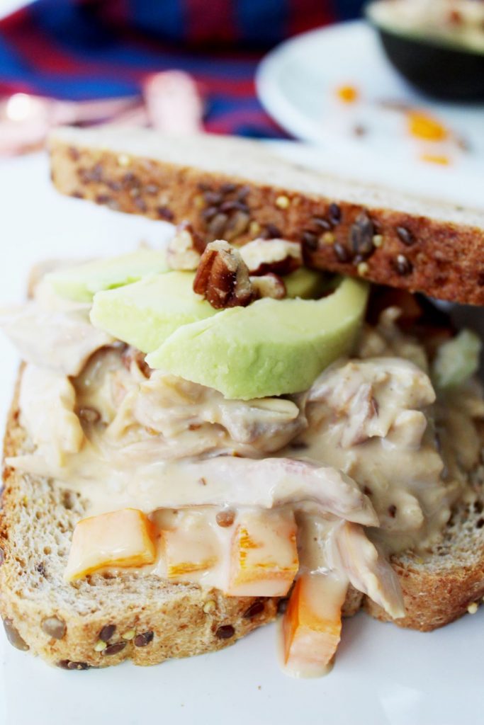 closeup chicken salad sandwich with avocado in back 1