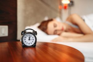 stay at home morning routine woman sleeping with alarm clock