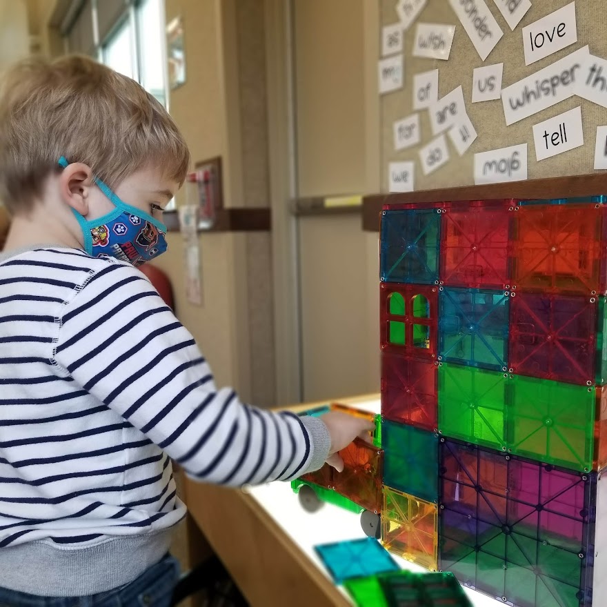 four year old playing with magnetic tiles